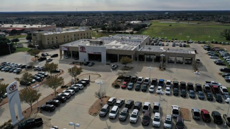 General view of Toyota car dealership with solar panels installed on the roof and parked cars